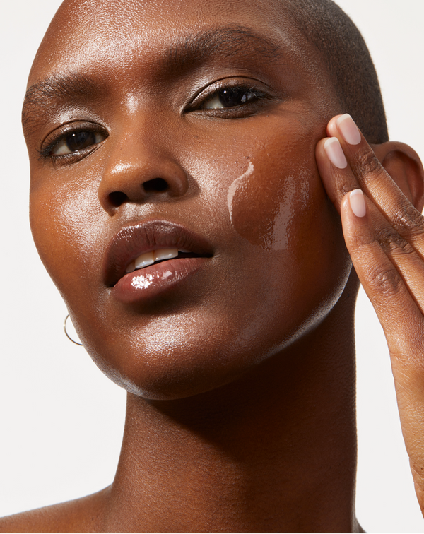 Model applying ACTIVE COCOONING SERUM to her face with her fingertips 