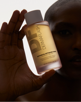 COMPLETE SONIC SKINCARE SET - Stone | model holding BOTANICAL KETOACID TONER with low lighting from the Complete Sonic Skincare Set in Stone