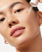 LUXE+ AND SERUM SET - Stone | Image of model applying Active Cocooning Serum on her cheek