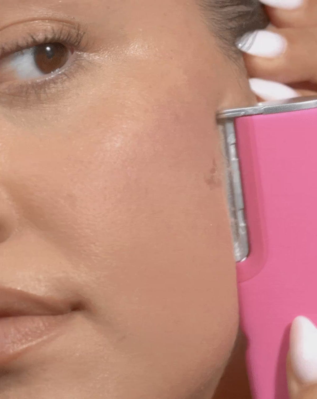 Pop Pink | Model demonstrating how to glide LUXE+ over your face in short, feathery strokes 