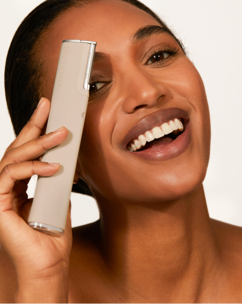 DERMAFLASH LUXE+ - Model holding LUXE+ dermaplaning device in Stone near her face 