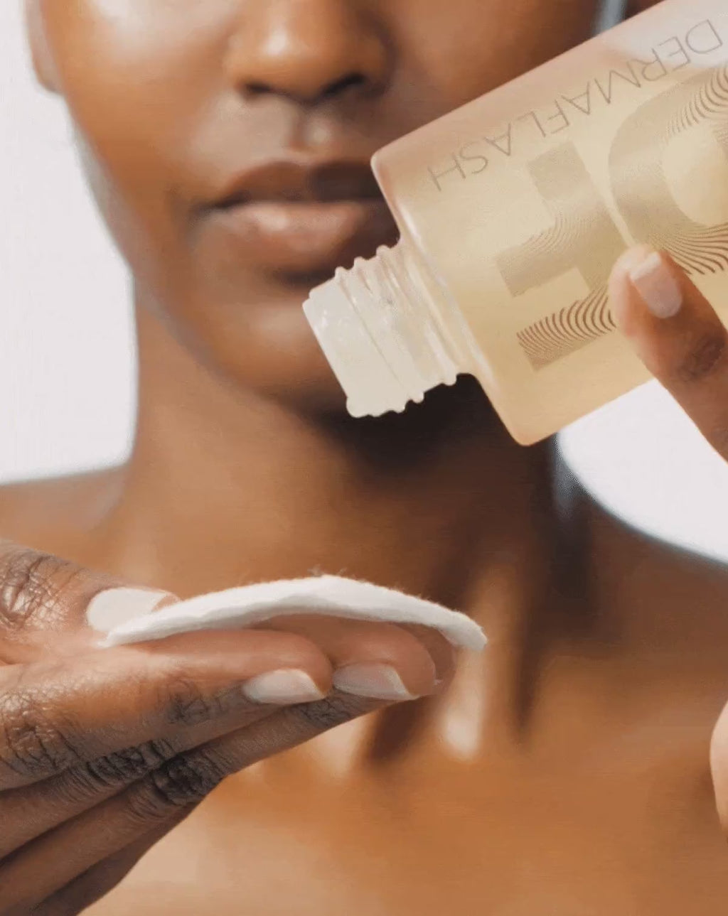 Model dispensing BOTANICAL KETOACID TONER onto a cotton pad and applying to her face 